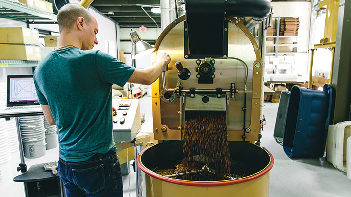 The head coffee roaster at work at One Village Coffee